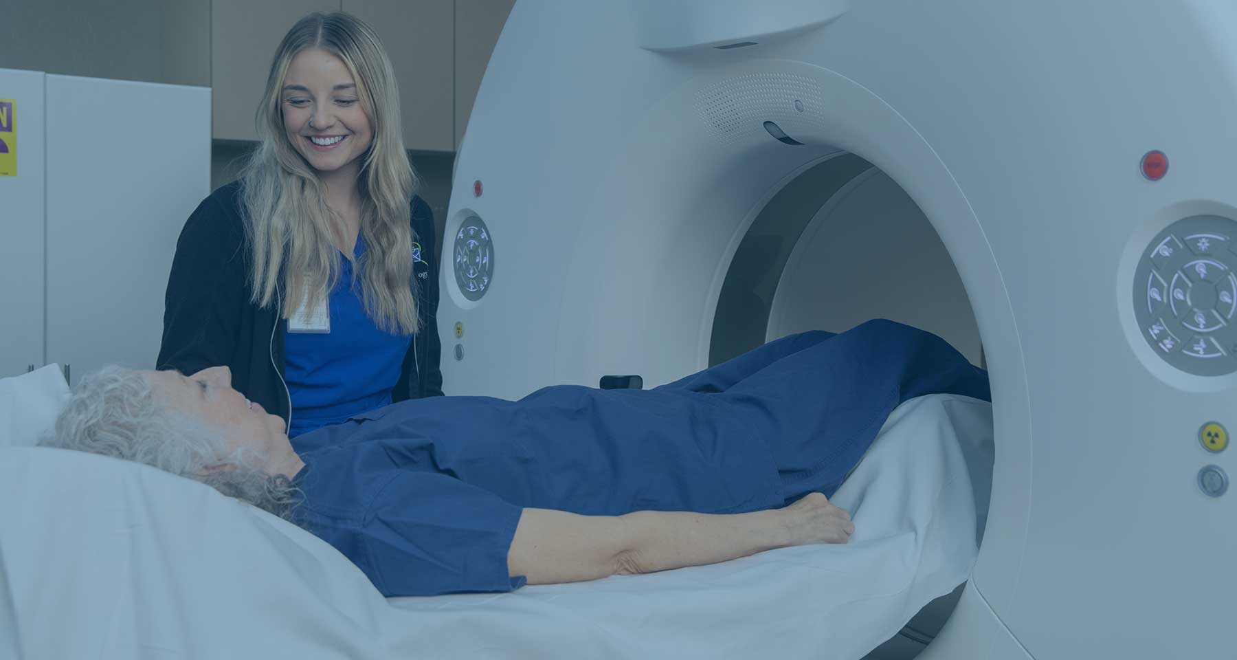 Technician working with a patient in front of imaging equipment