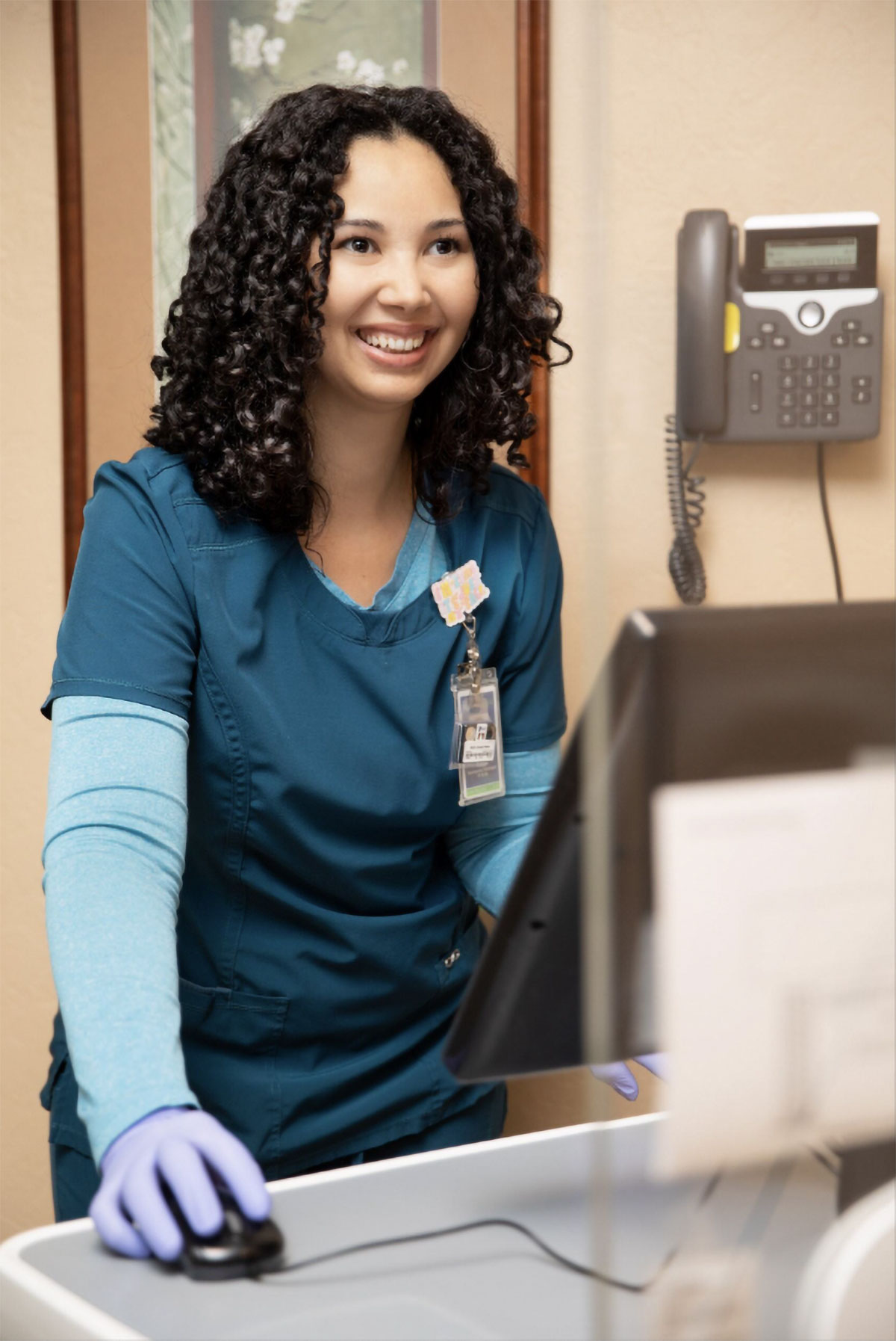 Technologist with patient before a mammogram